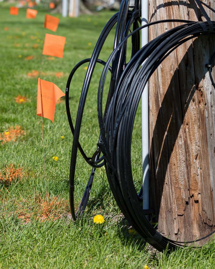 Câble de fibre optique, drapeaux de marquage orange et poteau utilitaire. Concept de creuser la sécurité, le service de localisation des services publics et l’Internet haute vitesse.