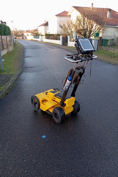 Service de détection de réseau : technicien utilisant un détecteur électromagnétique pour repérer un réseau enterré.