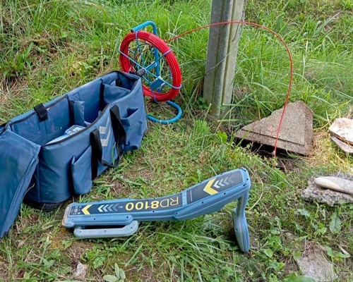 Recherche de canalisation enterrée : détecteur électromagnétique et aiguille.