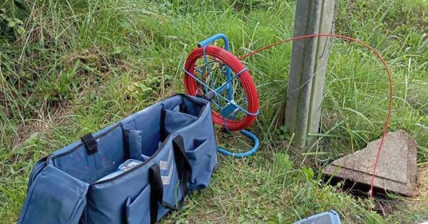 Entreprise débouchage fourreau fibre : technicien inspectant un regard telecom pour débouchage de fourreau fibre optique.