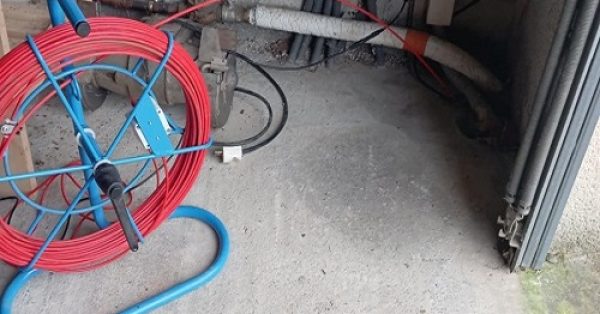 Vue détaillée d’un regard telecom en limite de propriété avec une plaque en métal.